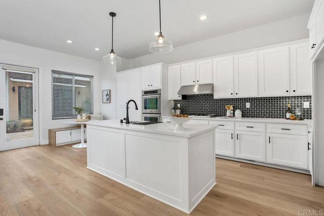 a kitchen with white cabinets and white appliances