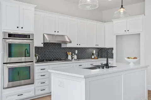 a kitchen with appliances a sink and cabinets
