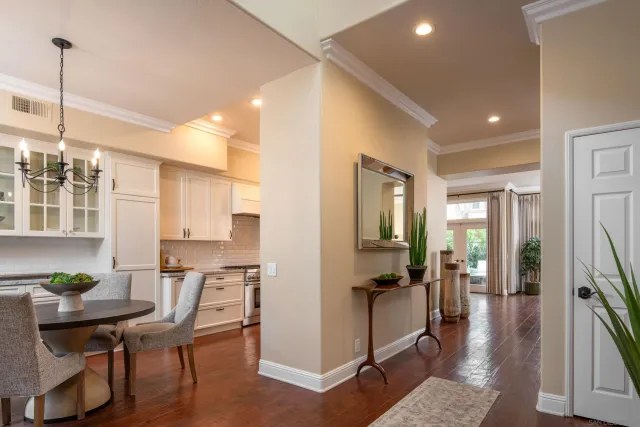 a living room with stainless steel appliances furniture a rug kitchen view and a chandelier