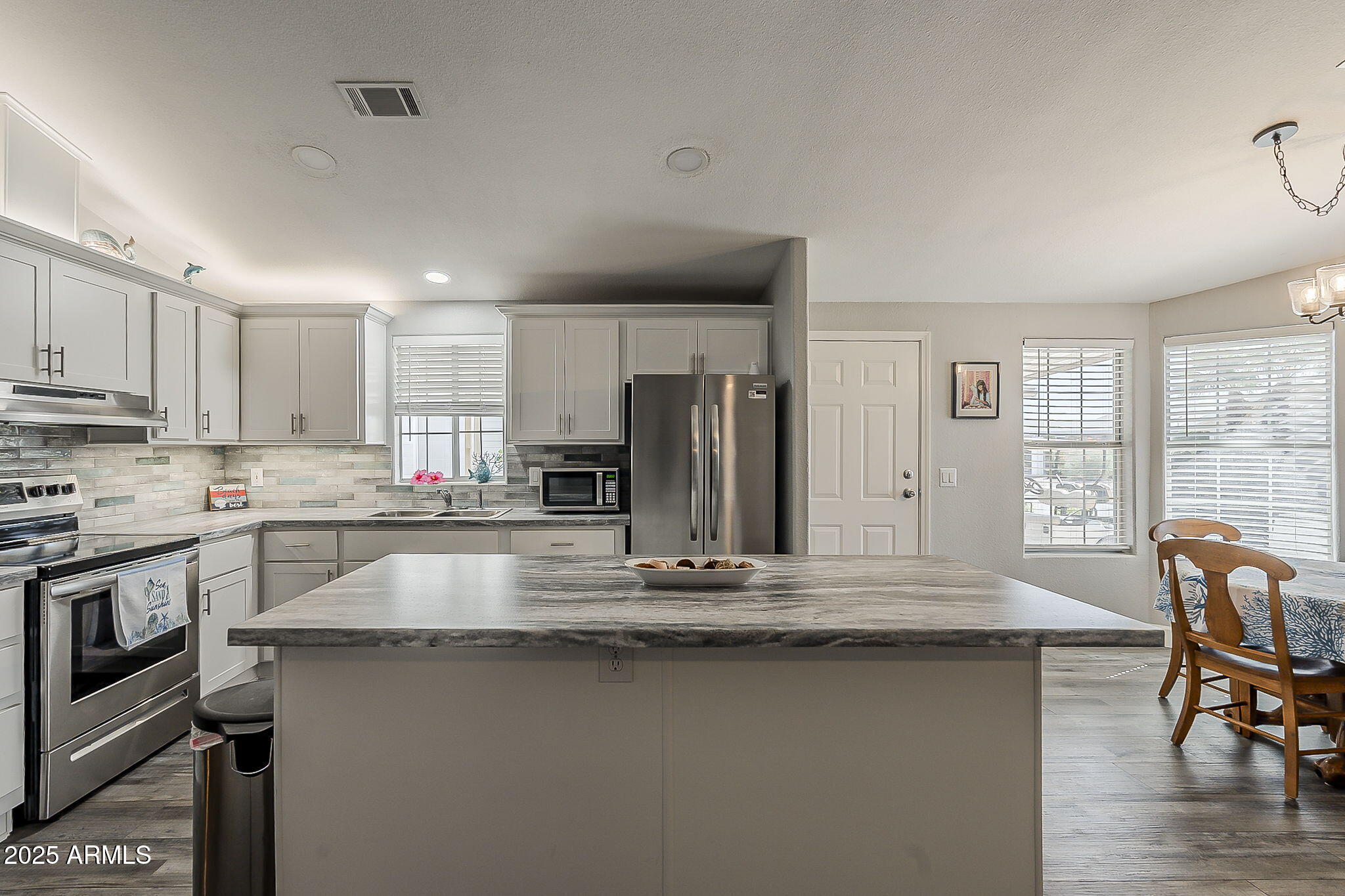 215 North Power Road, Unit 107 Mesa, AZ 85205 - Photo 4 of 49 a kitchen with stainless steel appliances granite countertop a stove a sink and a refrigerator