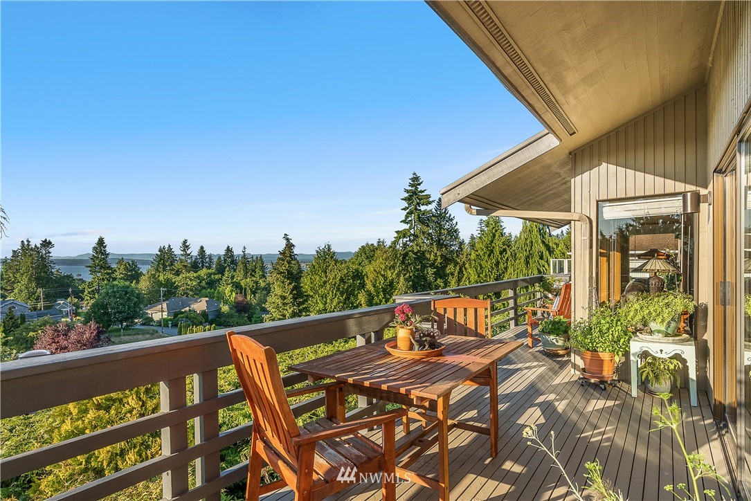 4910 23rd Avenue West Everett, WA 98203 - Photo 34 of 40 a view of a patio with table and chairs and floor to ceiling window plants and trees