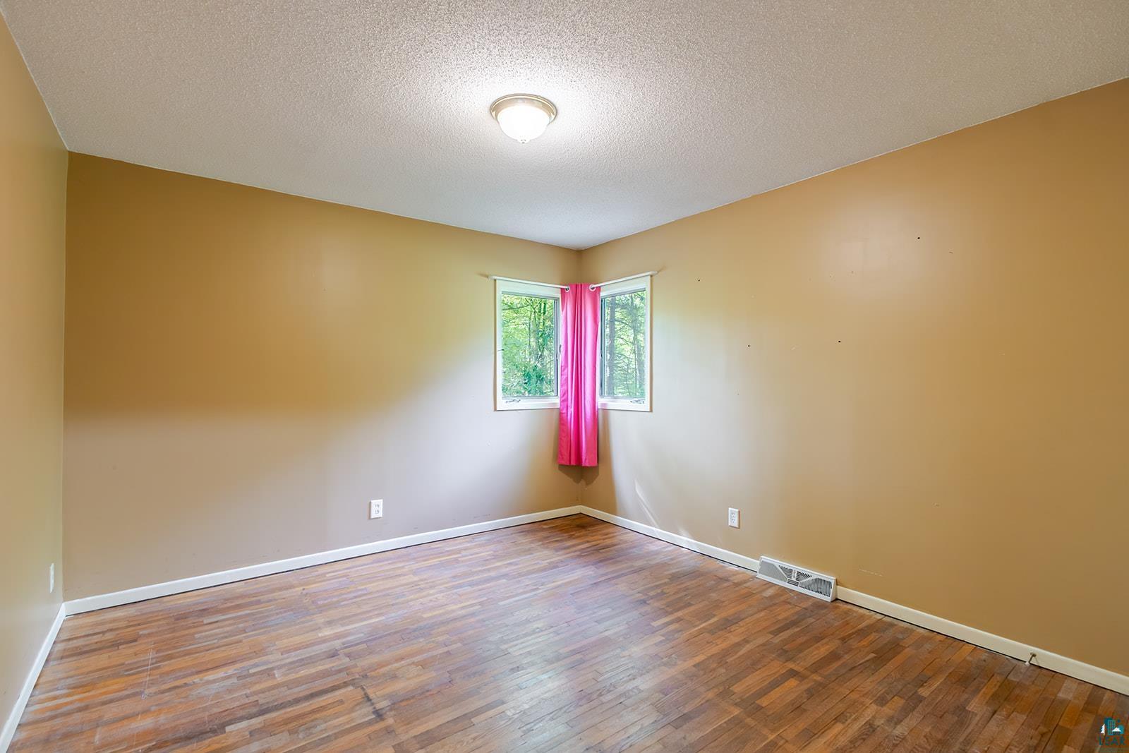 7045 Morris Thomas Road Cloquet, MN 55720 - Photo 16 of 28 Room featuring wood-finish flooring, neutral wall tones, and white trim
