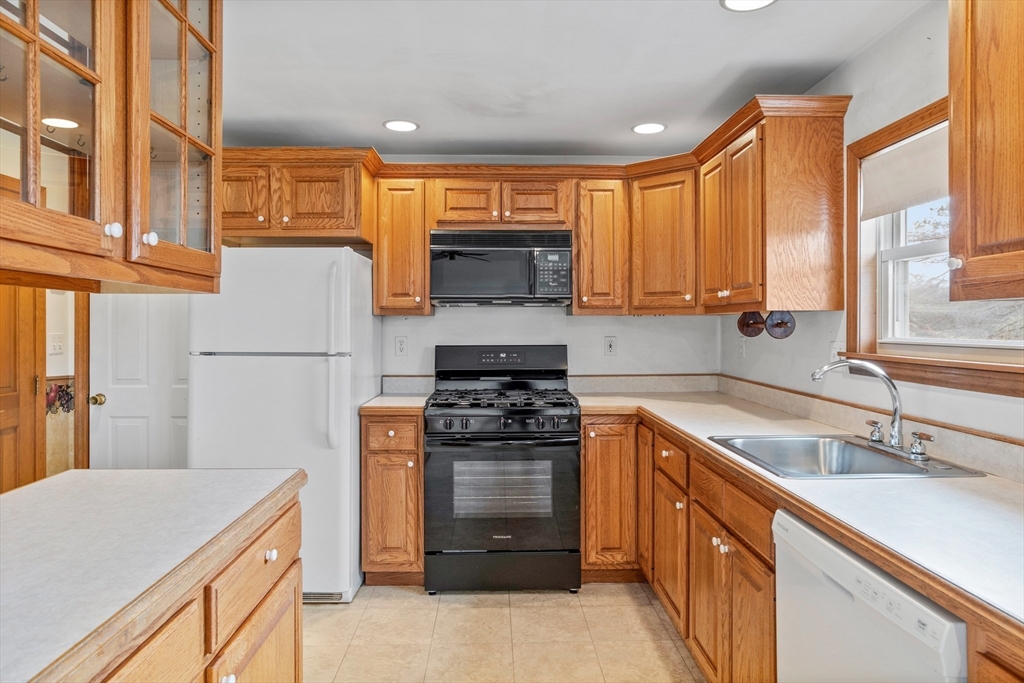 13 Lexington Road Billerica, MA 01821 - Photo 11 of 25 a kitchen with a stove a sink and a refrigerator