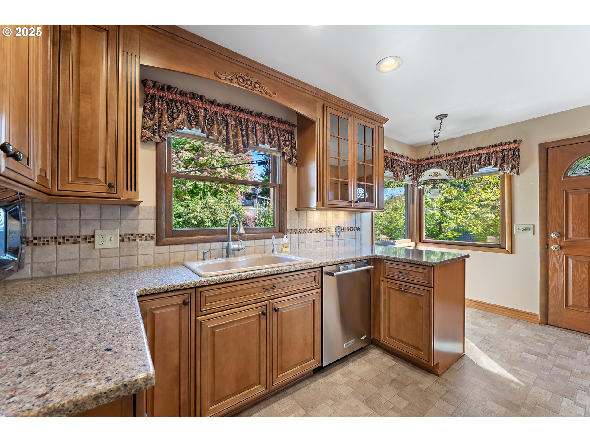 4430 Southeast Flavel Street Portland, OR 97206 - Photo 12 of 43 a kitchen with stainless steel appliances granite countertop wooden cabinets a sink and a large window