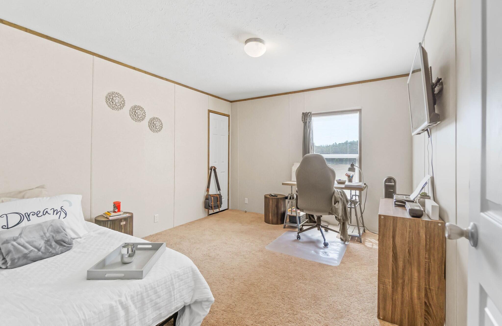 3139 Creek Road Bonifay, FL 32425 - Photo 13 of 41 a bedroom with a bed and a chair with the walls