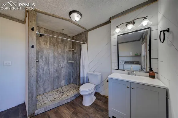 a bathroom with a granite countertop sink toilet and shower