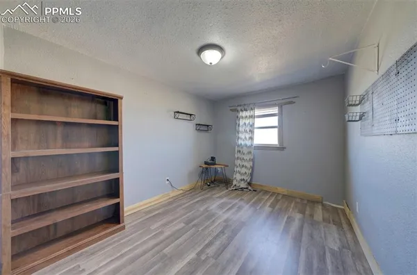 a view of room with wooden floor and furniture