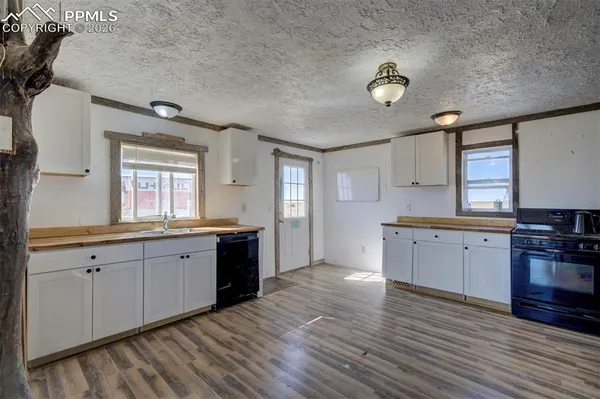 a large kitchen with stainless steel appliances granite countertop a stove and a wooden floors