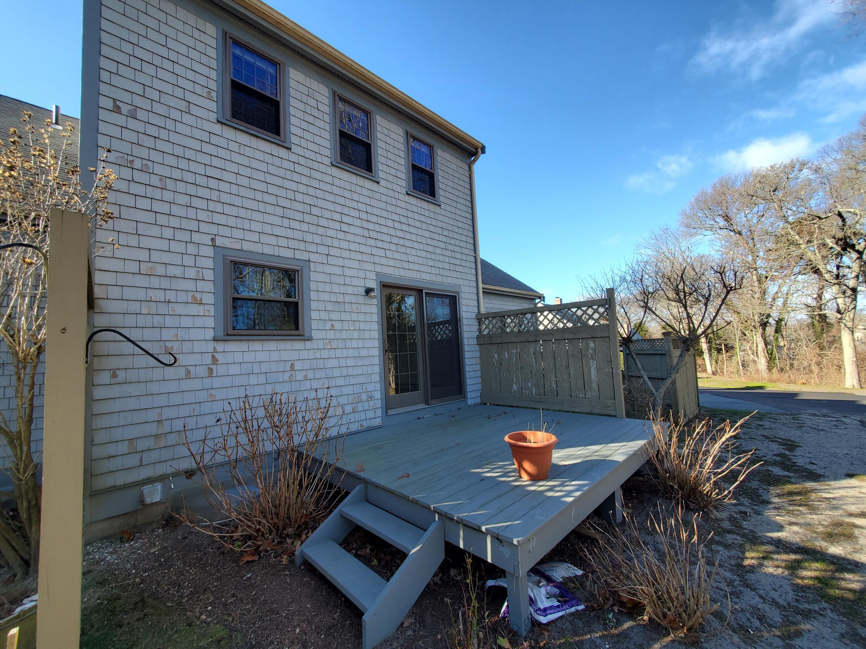 33 West Road, Unit 1B Orleans, MA 02653 - Photo 23 of 28 a backyard of a house with fire pit and outdoor seating