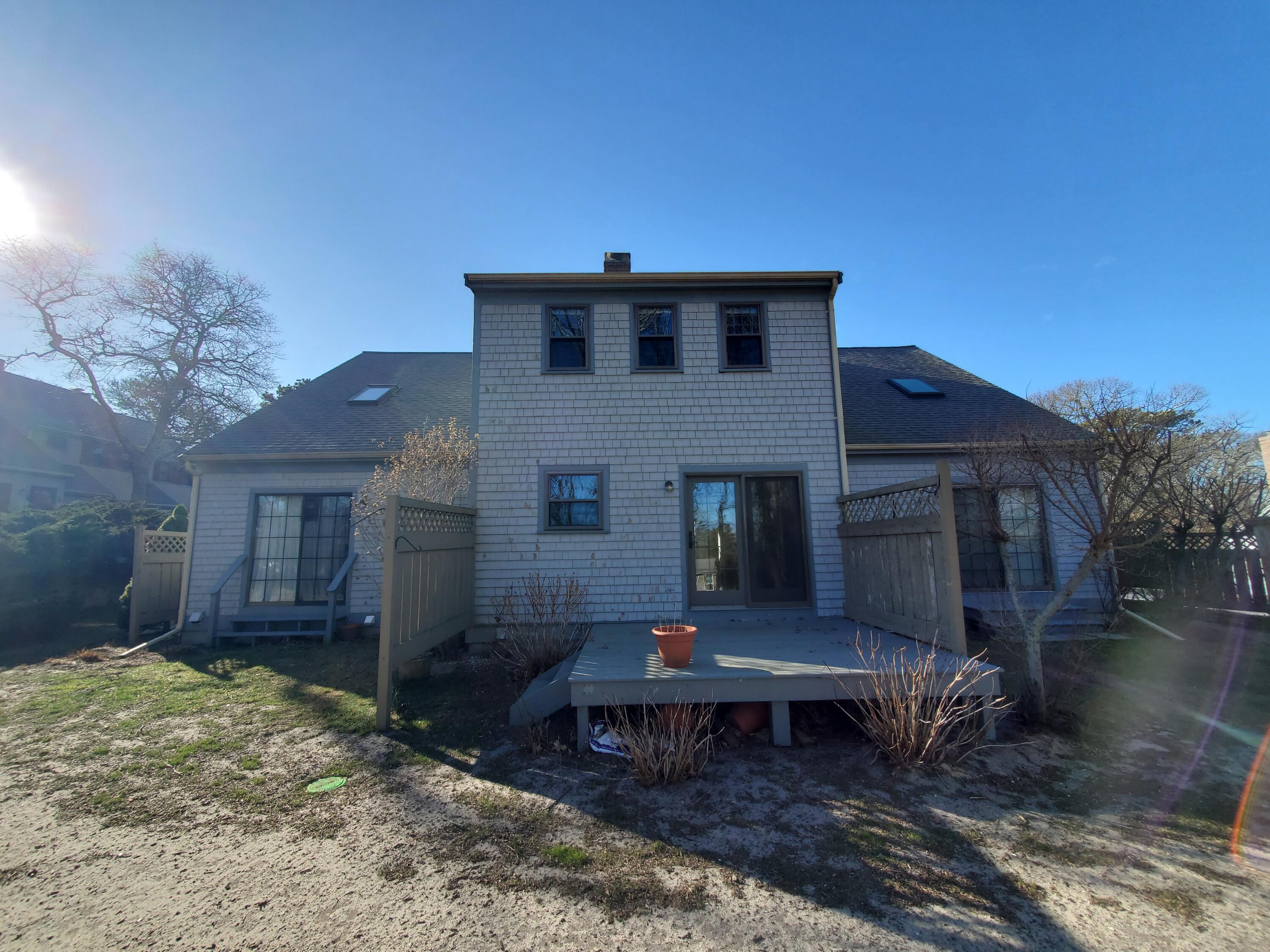 33 West Road, Unit 1B Orleans, MA 02653 - Photo 24 of 28 a backyard of a house with a table and chairs