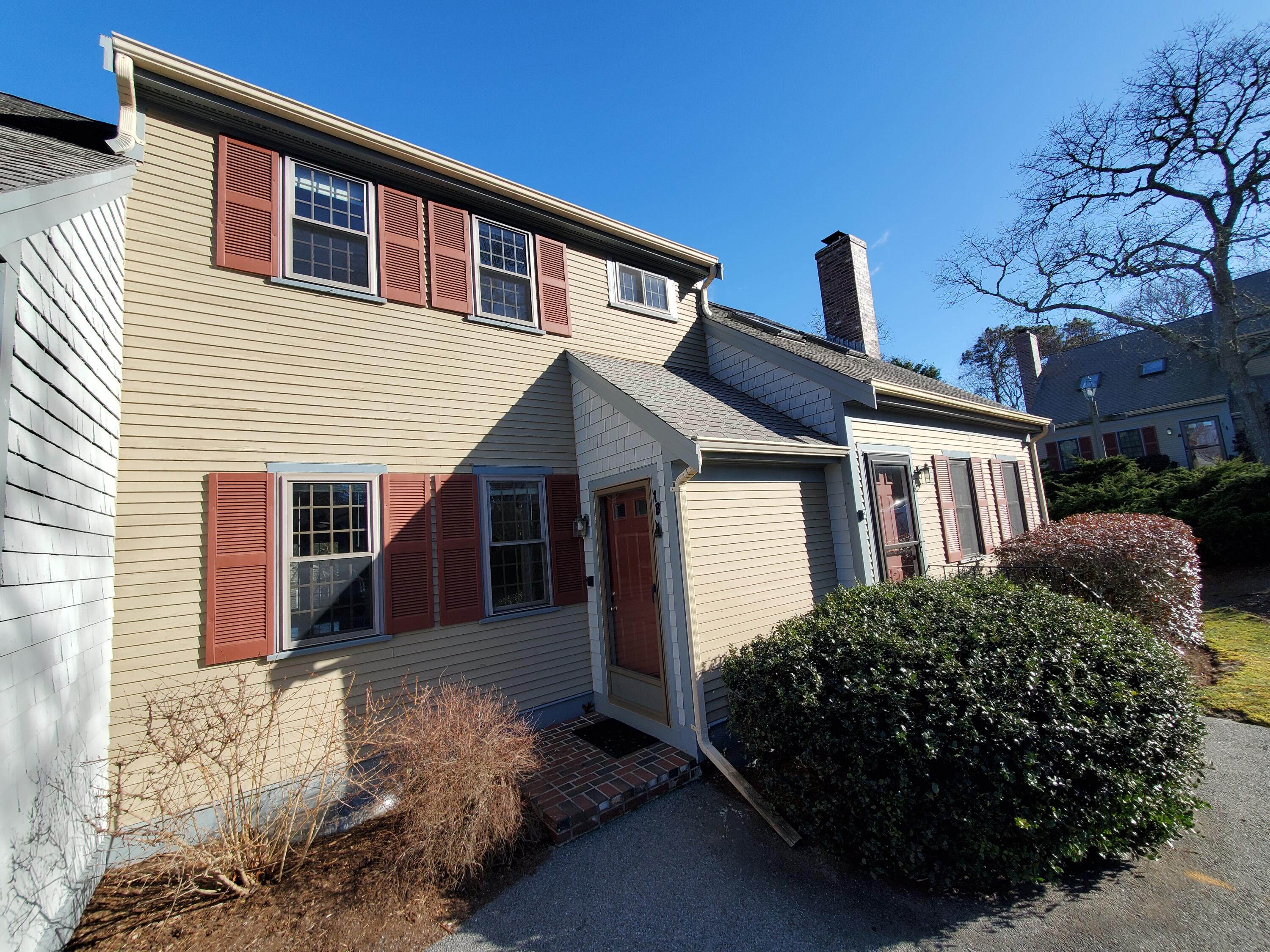 33 West Road, Unit 1B Orleans, MA 02653 - Photo 25 of 28 a front view of house with yard and trees in the background