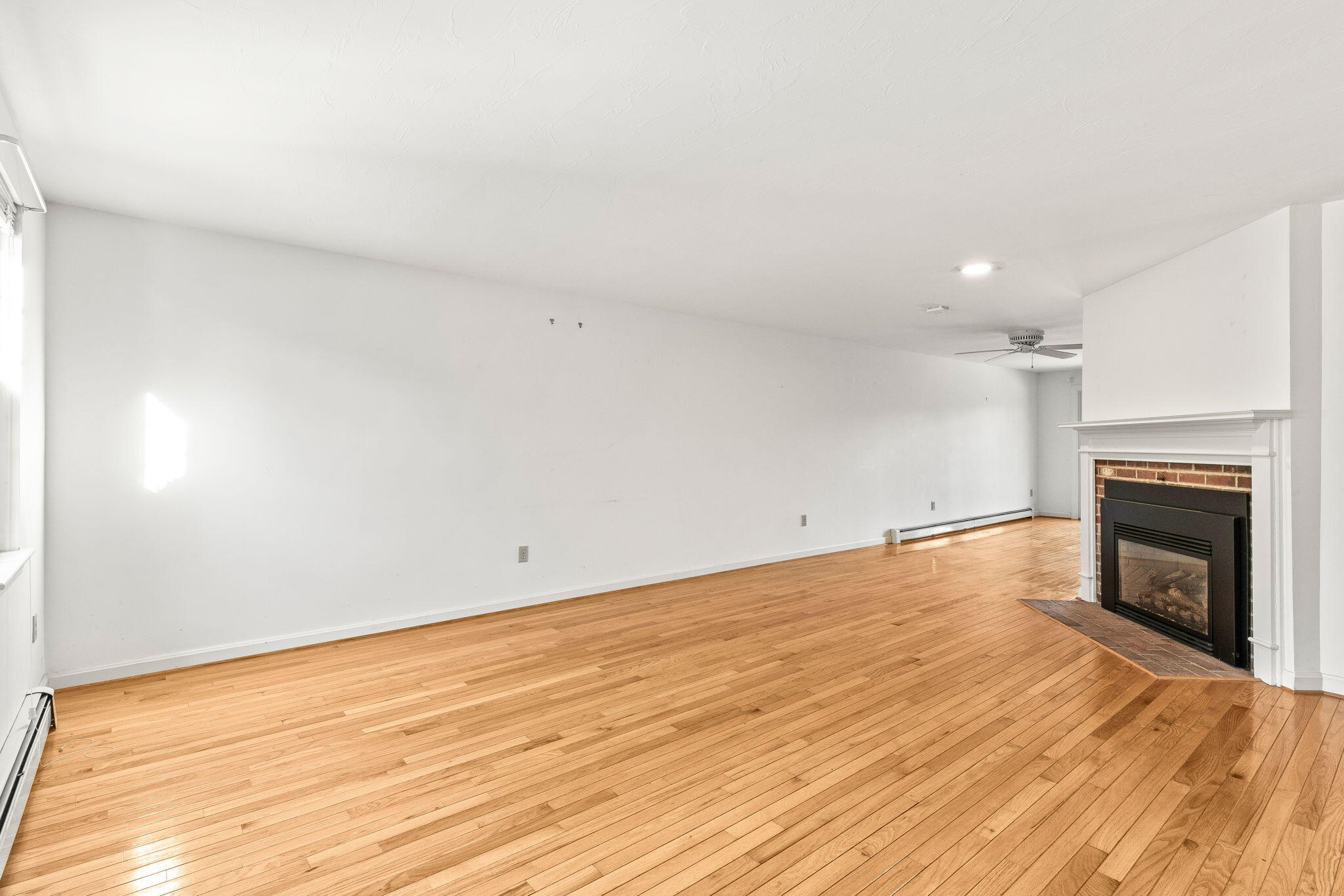 33 West Road, Unit 1B Orleans, MA 02653 - Photo 3 of 28 a view of empty room with wooden floor and fireplace