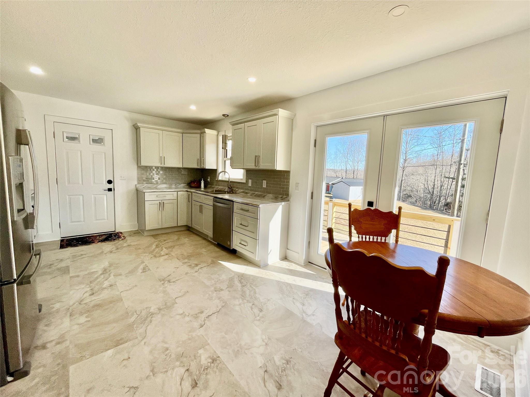 2019 Dale Road Spruce Pine, NC 28777 - Photo 7 of 18 a kitchen with stainless steel appliances a refrigerator a stove a dining table and chairs with wooden floor