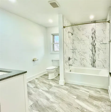 a bathroom with a bathtub shower sink and toilet