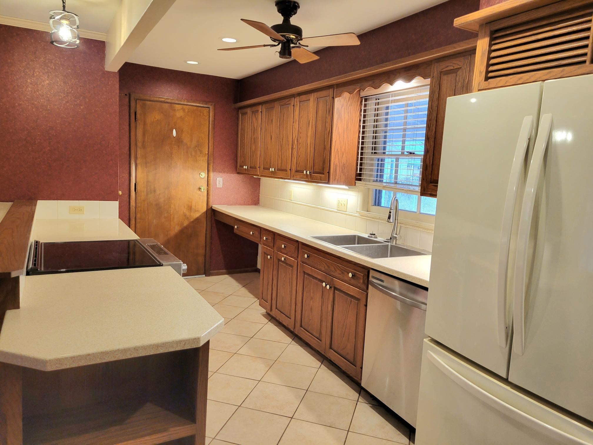 135 Redbud Drive Winfield, KS 67156 - Photo 3 of 29 The lovely kitchen has quartz counters, a brand new dishwasher, tile floors and two pantries, one of which can be used as the main floor laundry.
