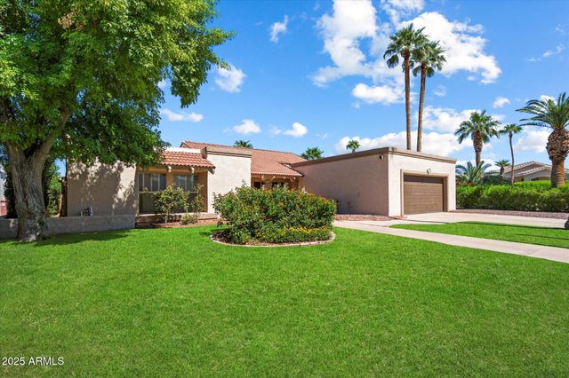 a view of a house with a yard and a garage
