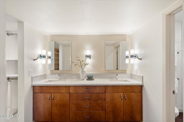 a bathroom with a granite countertop sink and a mirror