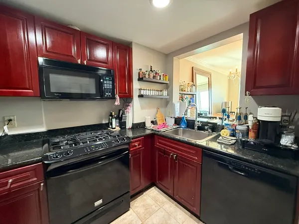 a kitchen with stainless steel appliances granite countertop sink stove top oven and cabinets