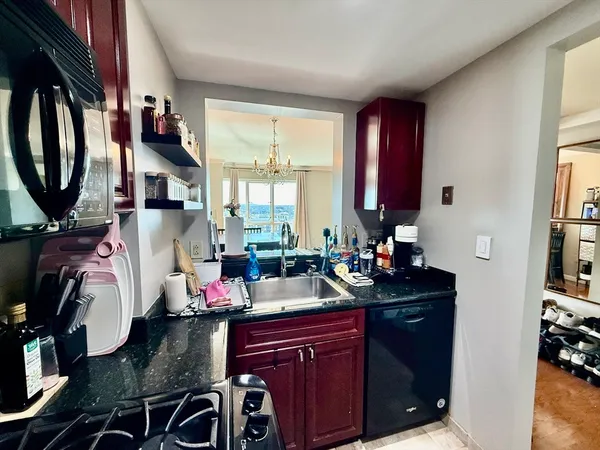 a kitchen with granite countertop a sink stove and cabinets