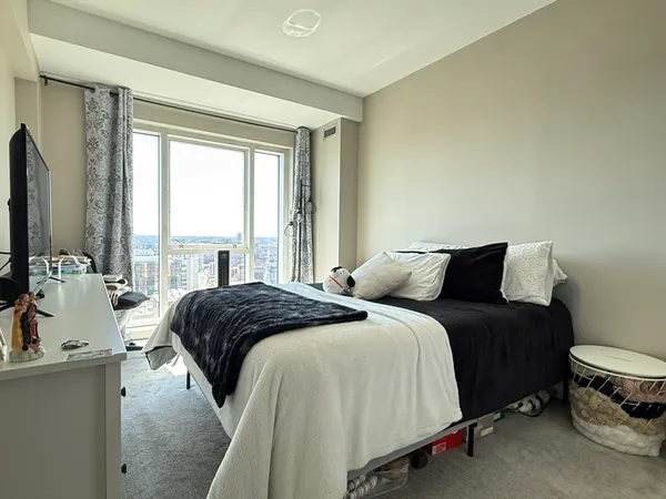 a bedroom with a bed and a large window