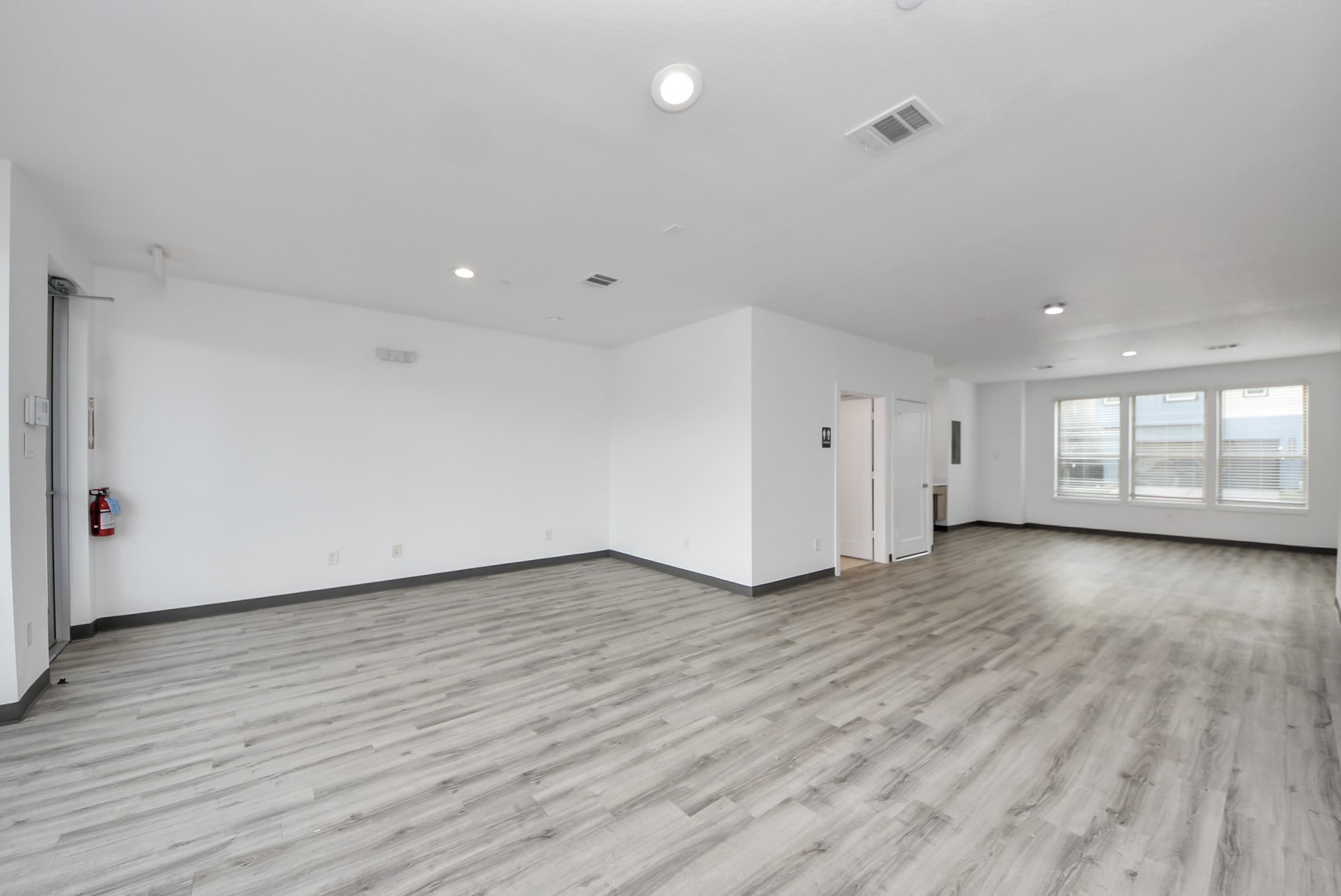 18716 Centro Main Street Conroe, TX 77385 - Photo 5 of 50 Spacious open-concept workspace with durable wood-style flooring, recessed lighting, and smooth white walls. Flexible layout allows for office, studio, showroom, or professional use with ample room for multiple workstations or client seating.
