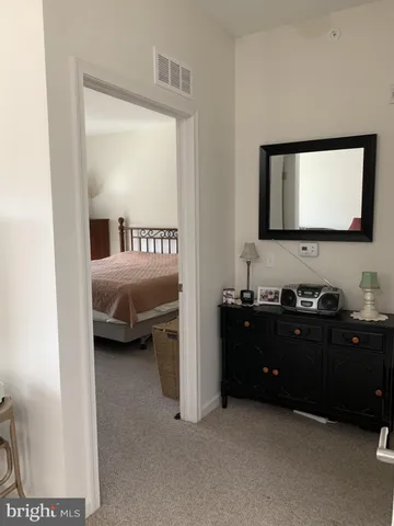 a room with a bed and a flat tv screen on dresser