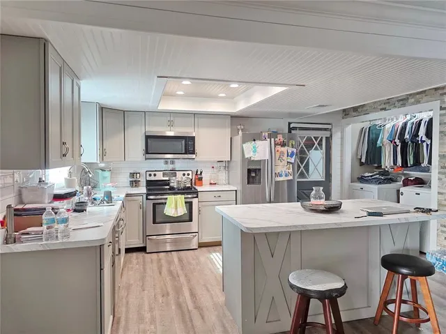 a kitchen with stainless steel appliances granite countertop a sink stove and refrigerator