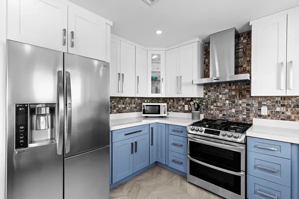 a kitchen with stainless steel appliances granite countertop a refrigerator stove and sink