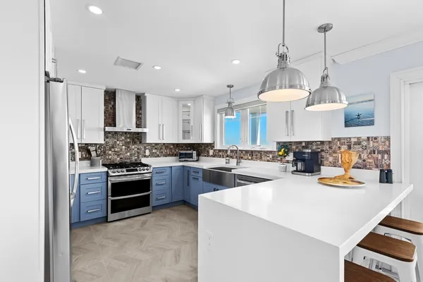 a kitchen with sink a stove and chairs
