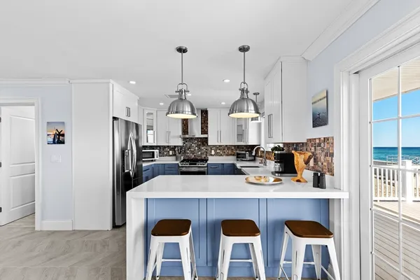 a kitchen with stainless steel appliances a dining table chairs and a refrigerator