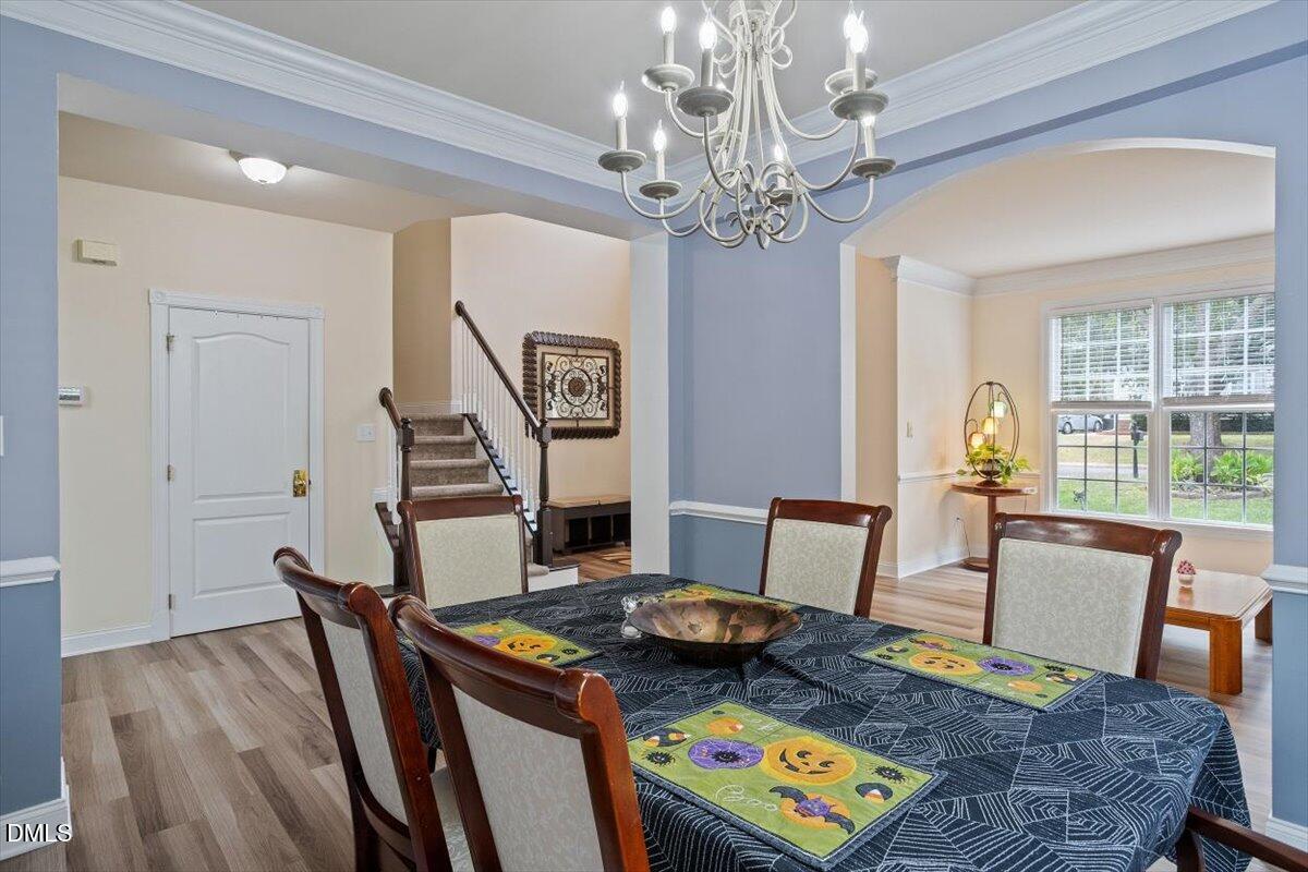 9208 Palm Bay Circle Raleigh, NC 27617 - Photo 13 of 54 a view of a dining room with furniture a chandelier and wooden floor