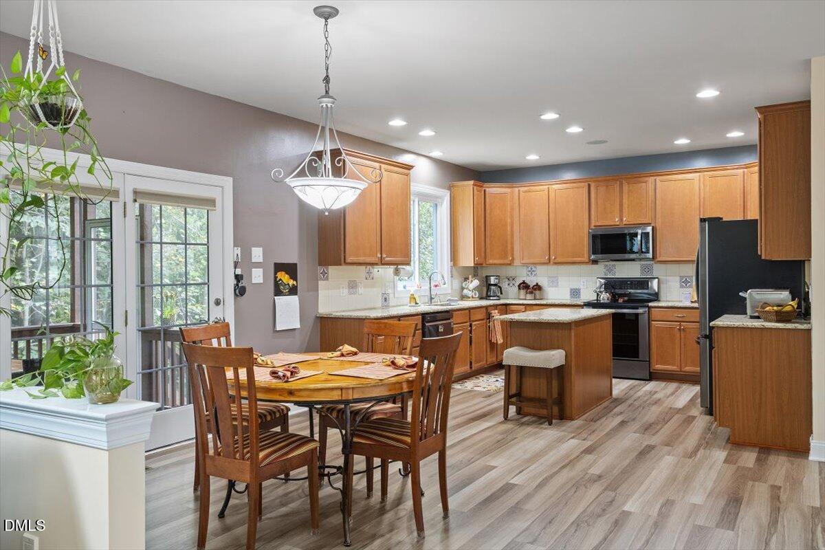 9208 Palm Bay Circle Raleigh, NC 27617 - Photo 18 of 54 a kitchen with granite countertop wooden floor dining table and chairs