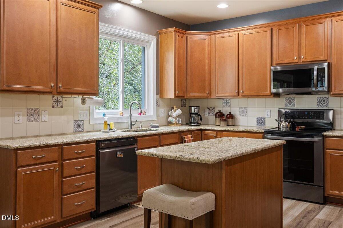 9208 Palm Bay Circle Raleigh, NC 27617 - Photo 23 of 54 a kitchen with a stove a sink and a microwave