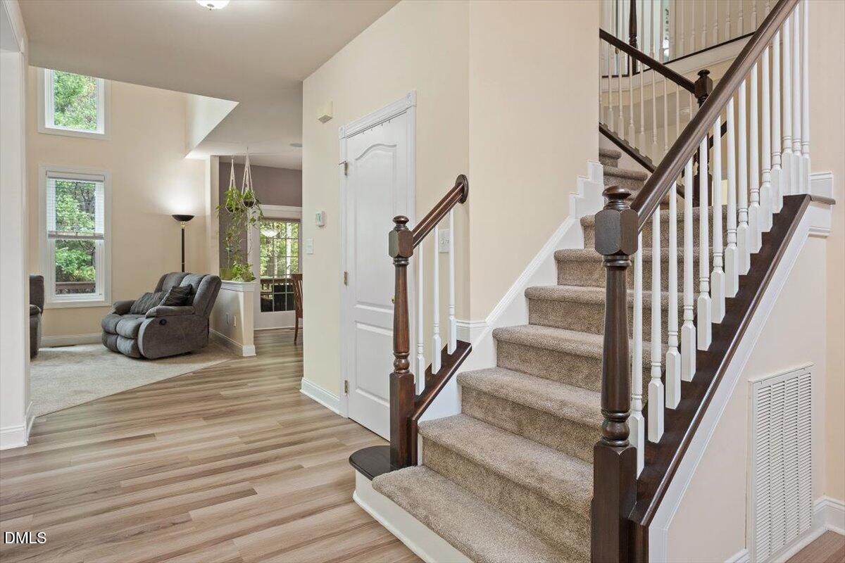 9208 Palm Bay Circle Raleigh, NC 27617 - Photo 31 of 54 a view of a livingroom with wooden floor and stairs