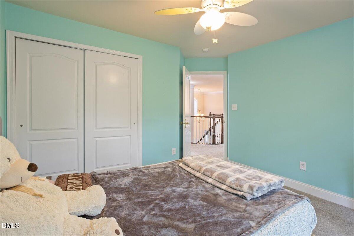 9208 Palm Bay Circle Raleigh, NC 27617 - Photo 42 of 54 a bedroom with a bed and a chandelier