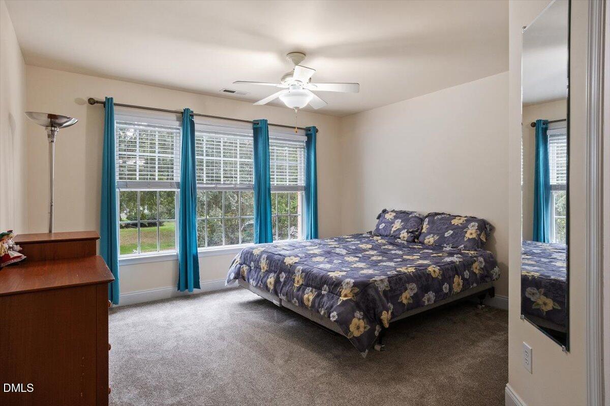 9208 Palm Bay Circle Raleigh, NC 27617 - Photo 47 of 54 a bedroom with a bed and a chandelier
