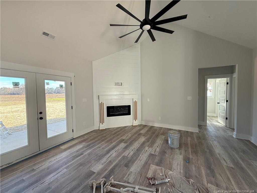 7166 Chicken Foot Road Hope Mills, NC 28348 - Photo 3 of 13 an empty room with wooden floor a ceiling fan and windows