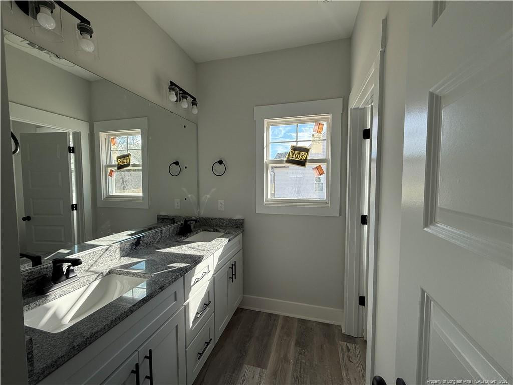 7166 Chicken Foot Road Hope Mills, NC 28348 - Photo 4 of 13 a bathroom with a granite countertop sink and a mirror