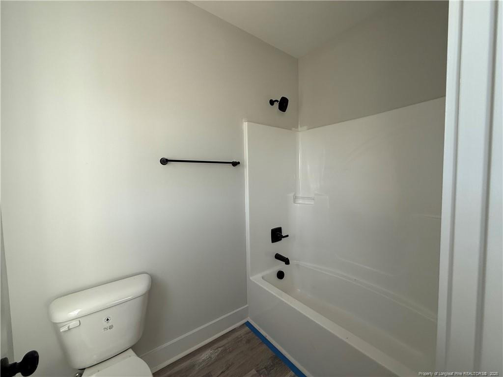 7166 Chicken Foot Road Hope Mills, NC 28348 - Photo 6 of 13 a bathroom with a bathtub and a toilet