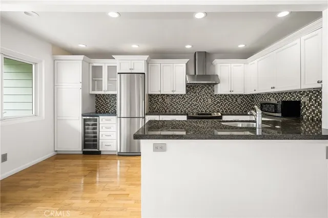 a kitchen with stainless steel appliances kitchen island granite countertop a refrigerator and a stove