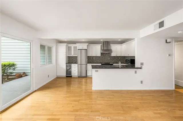 a kitchen with stainless steel appliances kitchen island granite countertop a refrigerator and a stove top oven