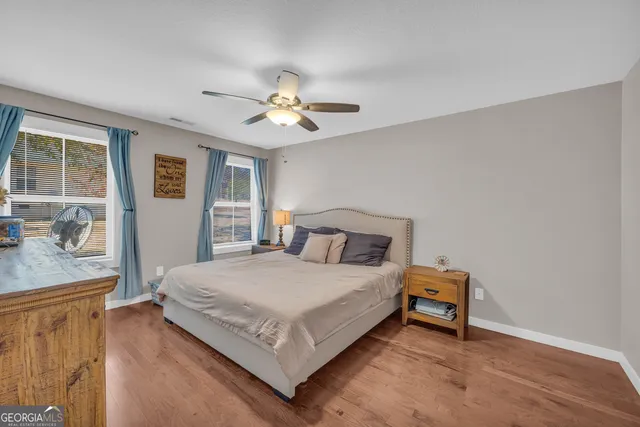 a spacious bedroom with a bed and a flat screen tv