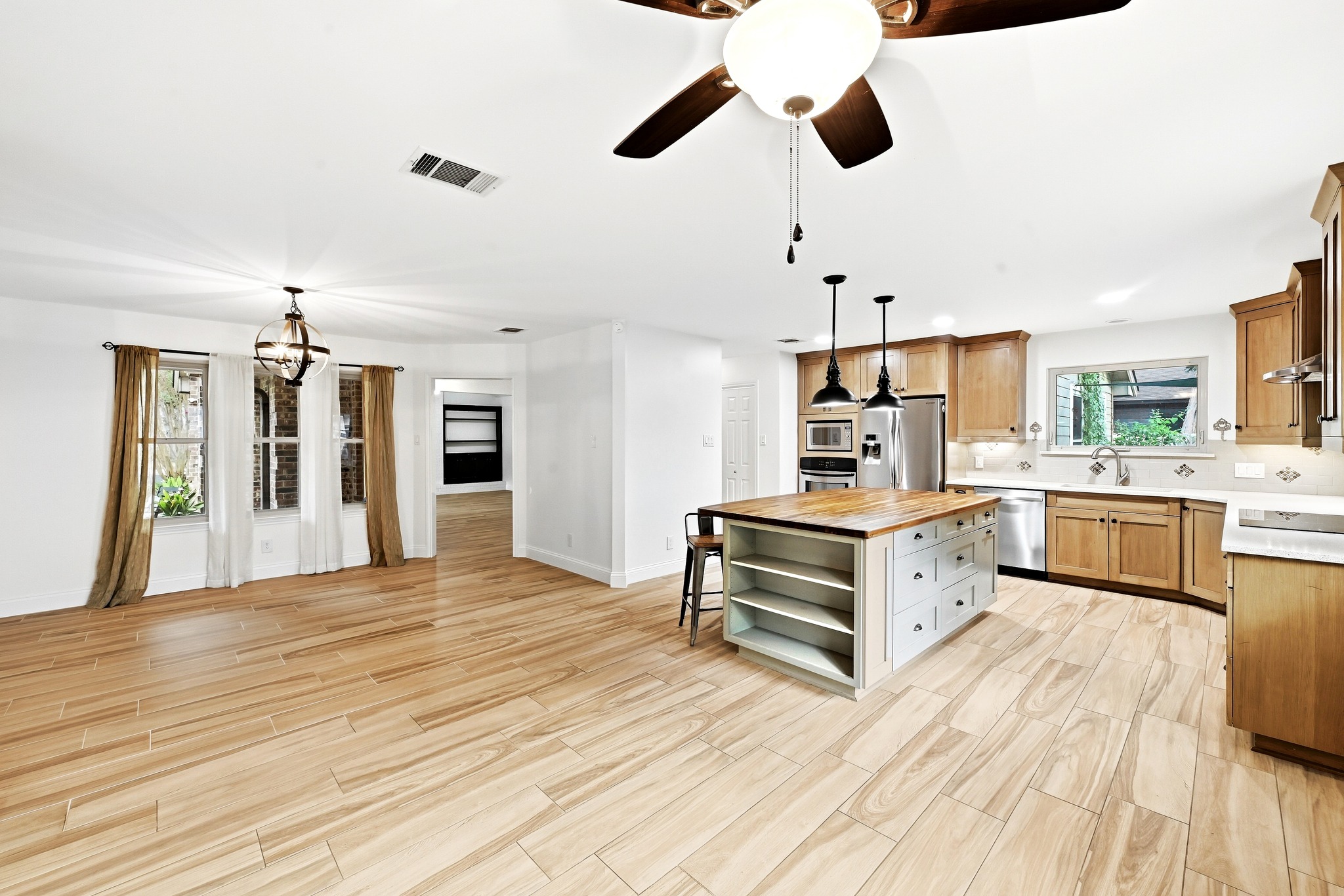 11218 Stormy Ridge Road Austin, TX 78739 - Photo 13 of 38 Warm wood tones and tile flooring define this bright, open kitchen and dining area.
