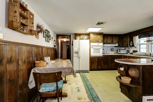 a kitchen with stainless steel appliances kitchen island granite countertop a refrigerator and a stove top oven