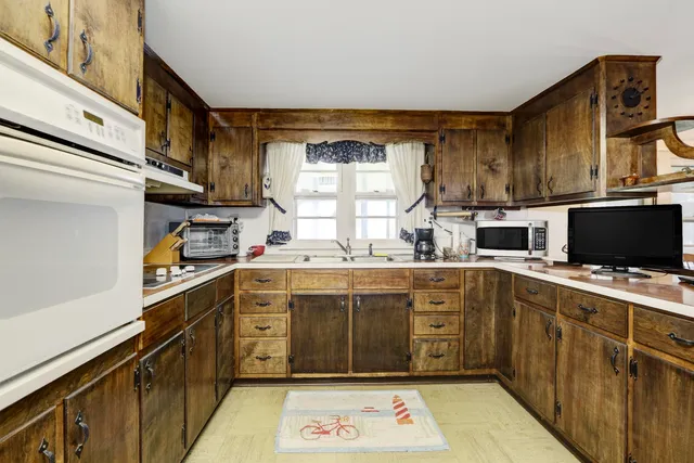 a kitchen with kitchen island granite countertop a sink and a stove top oven