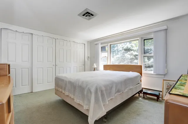 a bedroom with a bed and a window