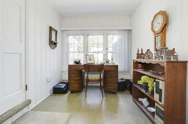 a view of a workspace with furniture and a window