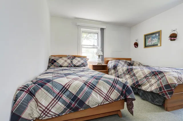 a bedroom with two beds and a window