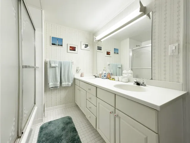 a en suite bathroom with a sink mirror and a shower