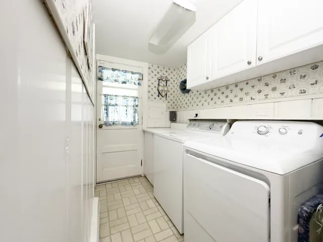 a utility room with cabinets washer and dryer